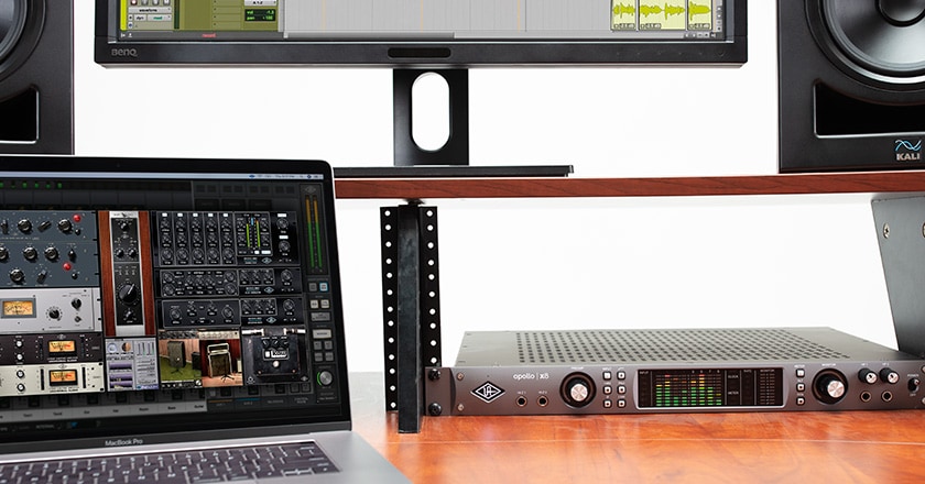 Apollo x8 rackmounted on a desk with UAD plugins on a laptop screen